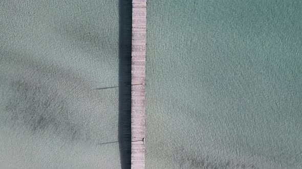 Straight Down view of Wooden Pier Going into Turquoise Blue Sea Water in Mallorca