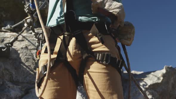 Young Caucasian man fastening zip lining harness