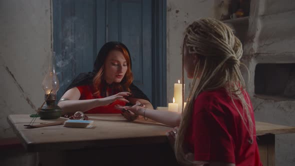 Fortune Teller Practicing Palm Reading To Woman