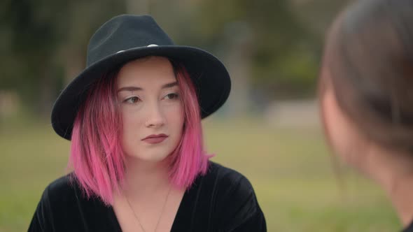 Nice Pink Haired Girl Using a Black Hat Talks to Another Girl