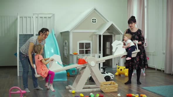 Mothers Holding Their Kids While Riding Swing