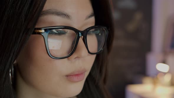 Closeup Portrait of Attractive Asian Lady Wearing Trendy Glasses Working in Office at Night