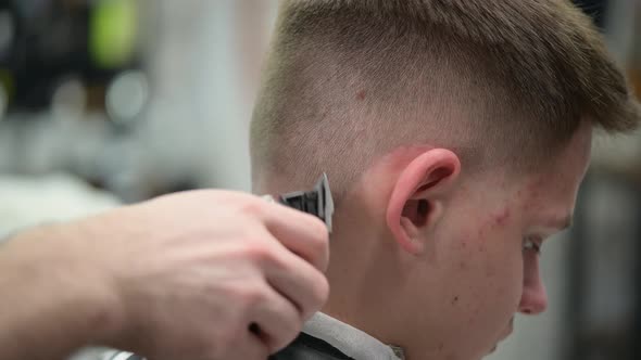 Haircut of the Young Man in Barbershop