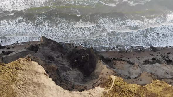 Aerial view of the steep slopes and waves at Rubjerg Knude by the North Sea, Denmark