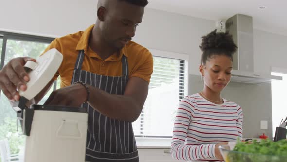 Video of happy african american couple cooking together in kitchen