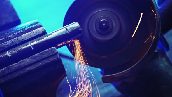 Professional Mechanic Cuts Off Metal Pipe with a Grinder Clamping Them in Vise