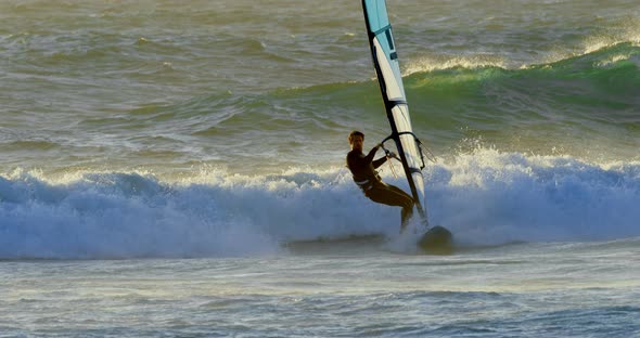 Male surfer windsurfing in the beach 4k