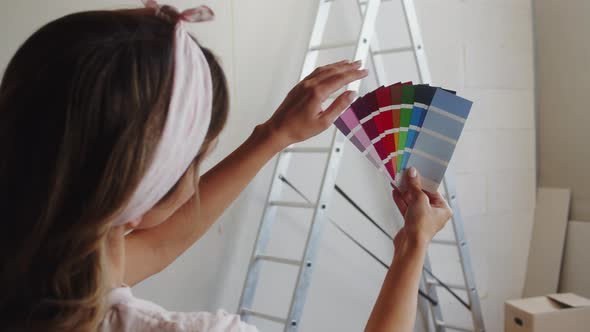 Woman Choosing Color for Painting Walls Holding Palette of Shades