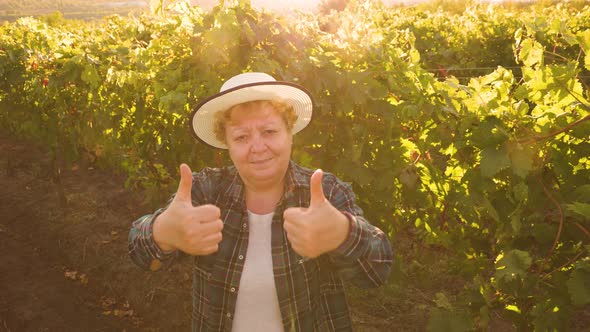 Happy Female Farmer with Hat Showing Thumb Up and Looking at Camera
