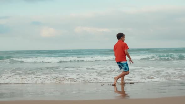 Happy Boy Dancing at Sand Beach in Holiday