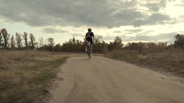 Cycling Athlete At Sunset Fall On Trail.Cyclist Twists Pedals And Riding On Gravel Bike.Gear System