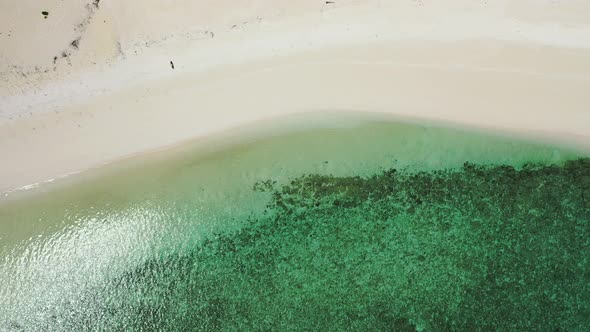 Wide angle overhead clean view of a summer white paradise sand beach and aqua blue water background 