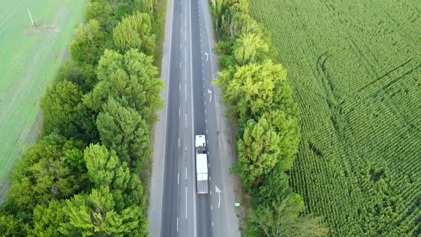 A Truck with a Container Travels on the Highway