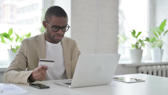 African Man Making Successful Online Payment on Laptop