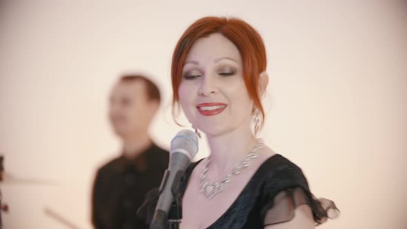 A Musical Band Playing a Song - Adult Ginger Woman Singing