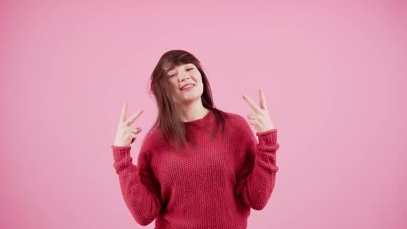 Happy Funny European Brunette with Hair Covering Her Face Showing Vsign to the Camera and Smiling