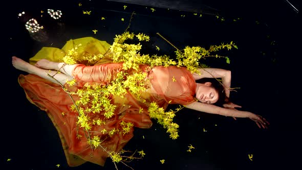 Woman is Relaxing in Water of Lake or Pool Charming Yellow Flowers Around Her Body