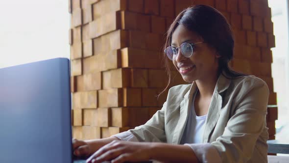 Smiling Young Indian Woman Blogger Influencer Sit in Cafe Working on Laptop