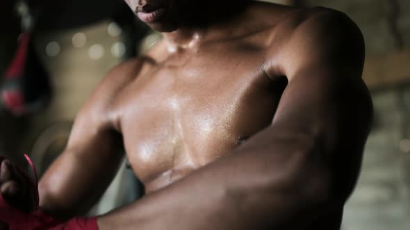 Boxer tying hand wrap in the gym