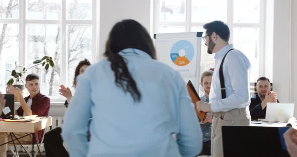 Camera Follows Happy Young Smiling Successful Businessman Entering Modern Office, Colleagues Clap To