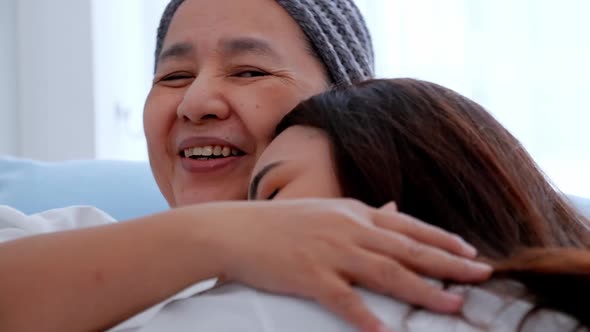 Young daughter encourages and comforts a mother with cancer during hospitalization.