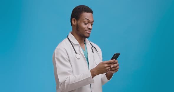 Medical Chat. Young Doctor Texting with Patient on Cellphone and Smiling, Modern Communicatio