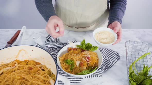 Step by step. Serving a one-pot pasta into a white pasta plate.