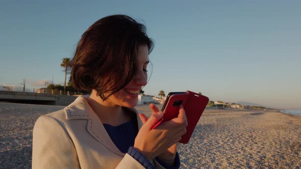 Girl is using the smartphone at Ocean