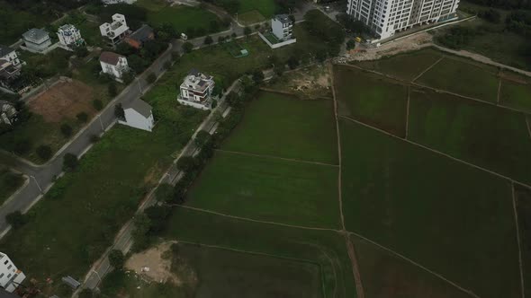 drone shot of rice fields and new villa and high rise development on the outskirts of Ho Chi Minh Ci