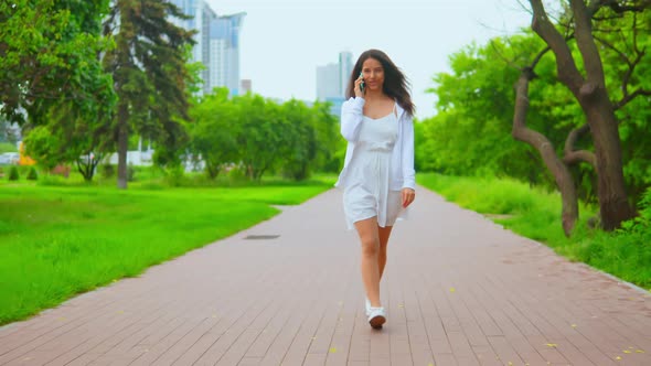 Front View Woman Walking Has Phone Conversation