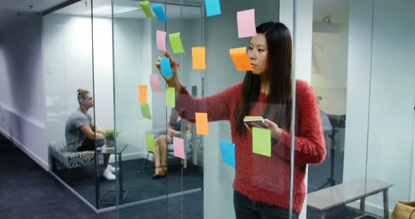 Female executive writing on stick notes