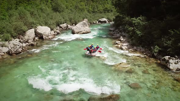 Aerial view of a group in a rafting boat going through the rocks at Soca River.