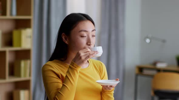 Pretty Asian Woman Enjoying Cup of Fresh Espresso at Home Enjoying Hot Coffee in Morning Slow Motion