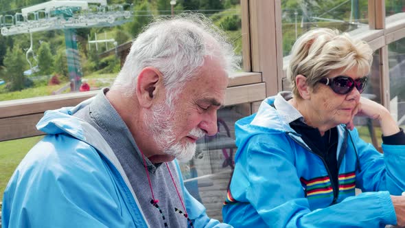 Elderly People Relaxing Outdoor at a Restaurant Table in a Mountain Landscape