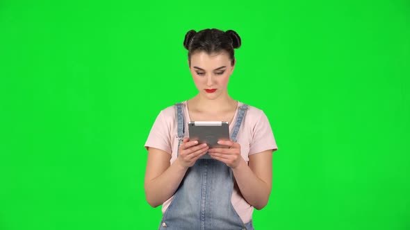 Upset Woman Reads Information on Her Tablet Computer at Studio.