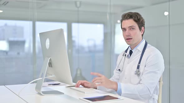 Cheerful Young Male Doctor Pointing Finger at Camera