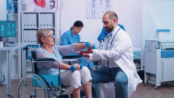 Doctor Helping Disabled Patient to Recover Muscle Strength