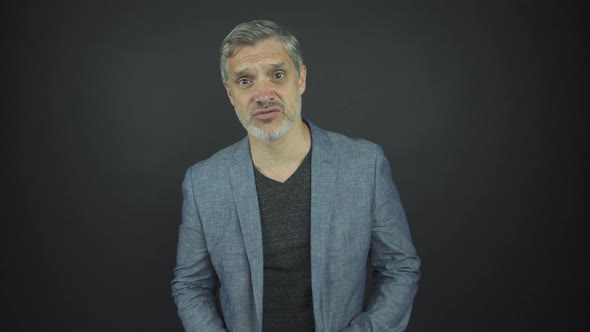 Mature Actor with Grey Hair and Beard Looks Straight Talking