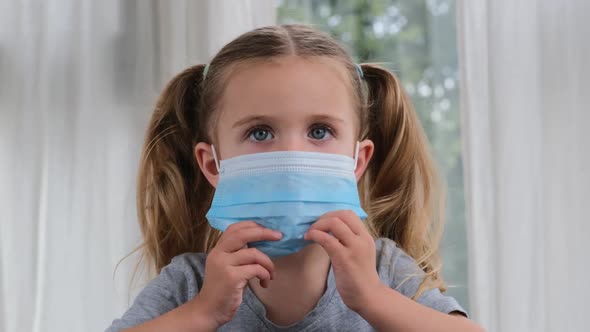 Cheerful Little Girl Smiles Holding Disposable Face Mask