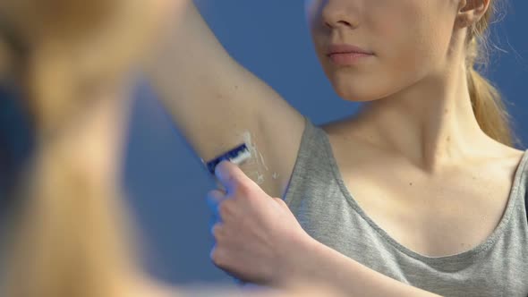 Young Lady Shaving Armpits in Bathroom, Morning Beauty Procedure, Hygiene