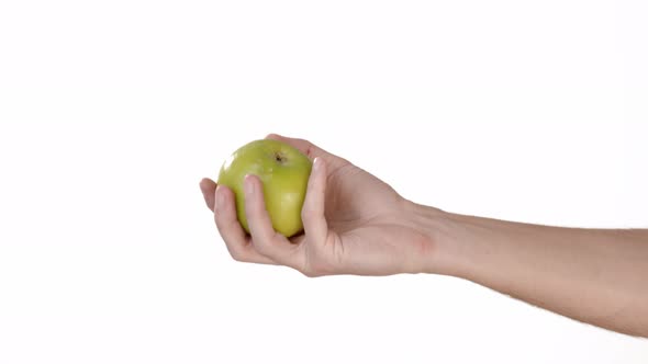 A Man's Hand on a White Background of Isolate Holds a Green Apple and Throws It. Place To Insert