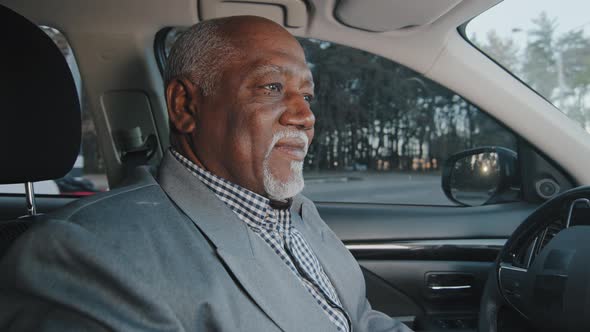 Elderly African American Businessman Driving Automobile on Roadway Experienced Confident Driver