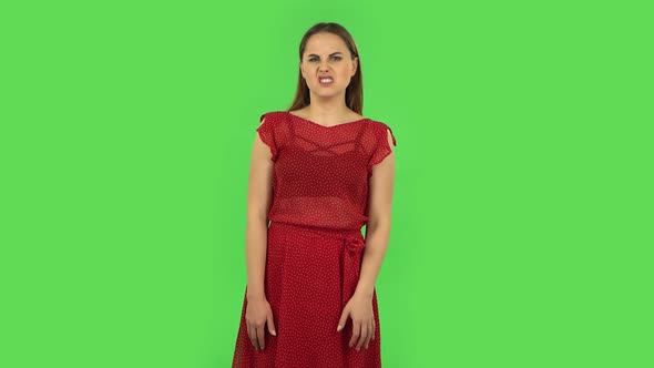 Tender Girl in Red Dress Is Showing Disgust for Bad Smell or Taste. Green Screen