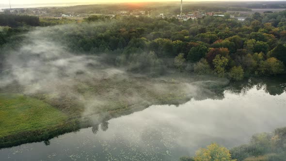 The Fog Slowly Floats Over the River on a Quiet Summer Evening  Aerial Drone Shot