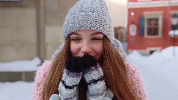 Smiling Traveler Girl Rubs Her Hands in Gloves Trying To Keep Warm in Frosty Weather on City Street