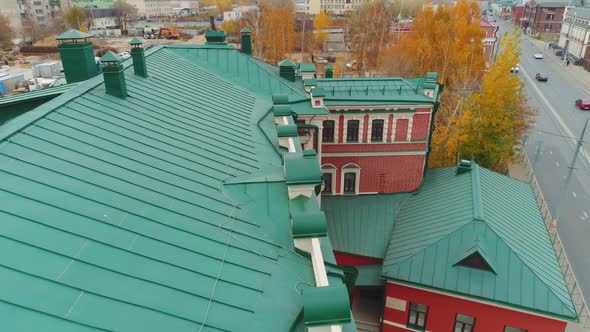 Green Roofed Old Building with Red White Facade on Street