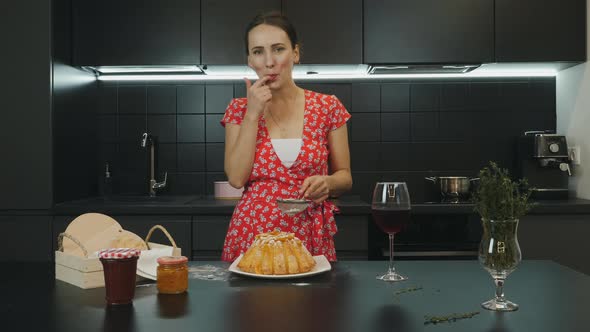 Beautiful woman smiling to camera, trying ingredients and preparing sweets at home. Food concept