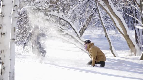 Happy Romantic Couple Playing with Snow at Sunny Winter Day