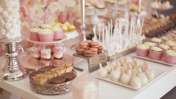 Cute Candy Bar with Various Cakes and Candies. Wedding Candybar.