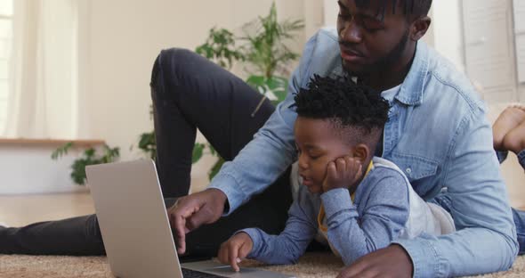 Father and son using technology together at home